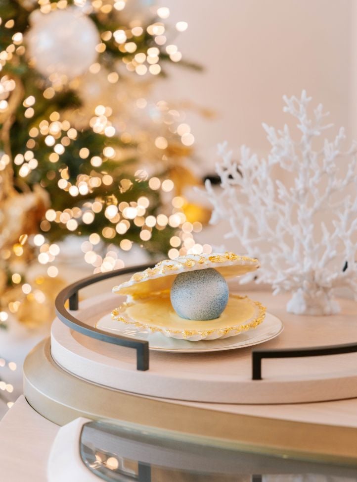 Coquillage posé sur une table devant un sapin illuminé